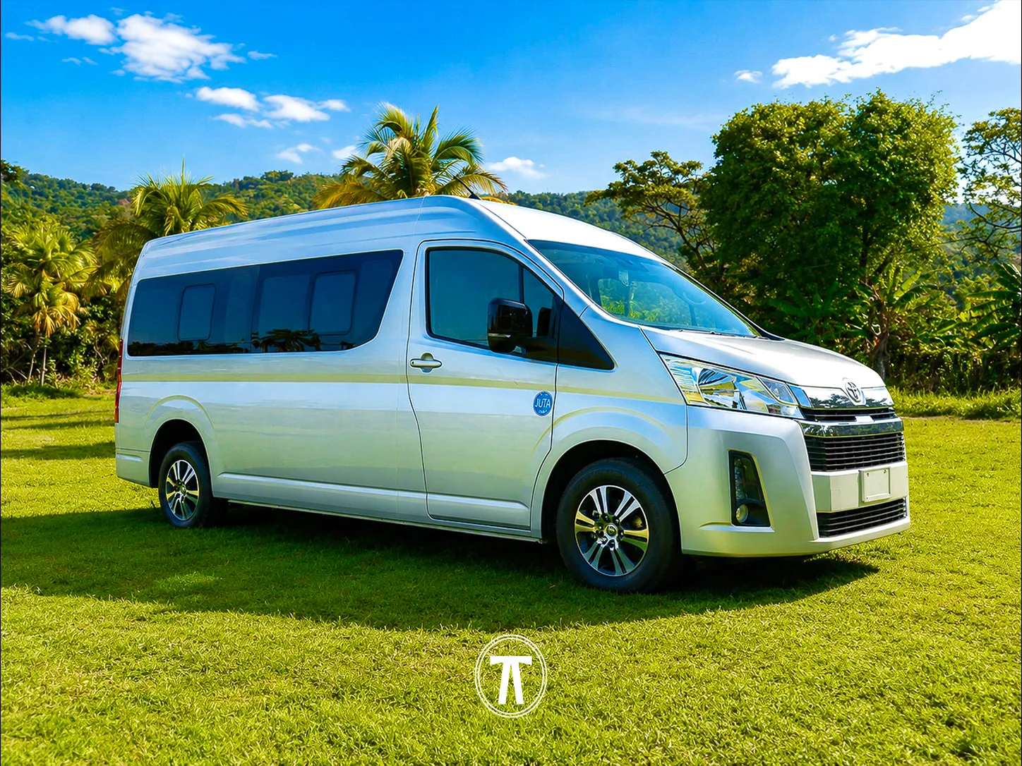 Silver passenger van with JUTA certification sticker, parked in a tropical Jamaican setting