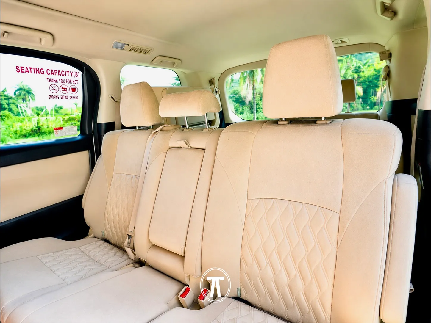 Van interior showing eight-seat capacity signage, with tropical greenery visible through the windows