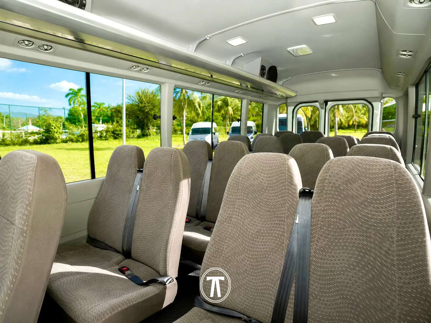 Coach interior with rows of seats, other Nakdar Transport vehicles visible through the windows