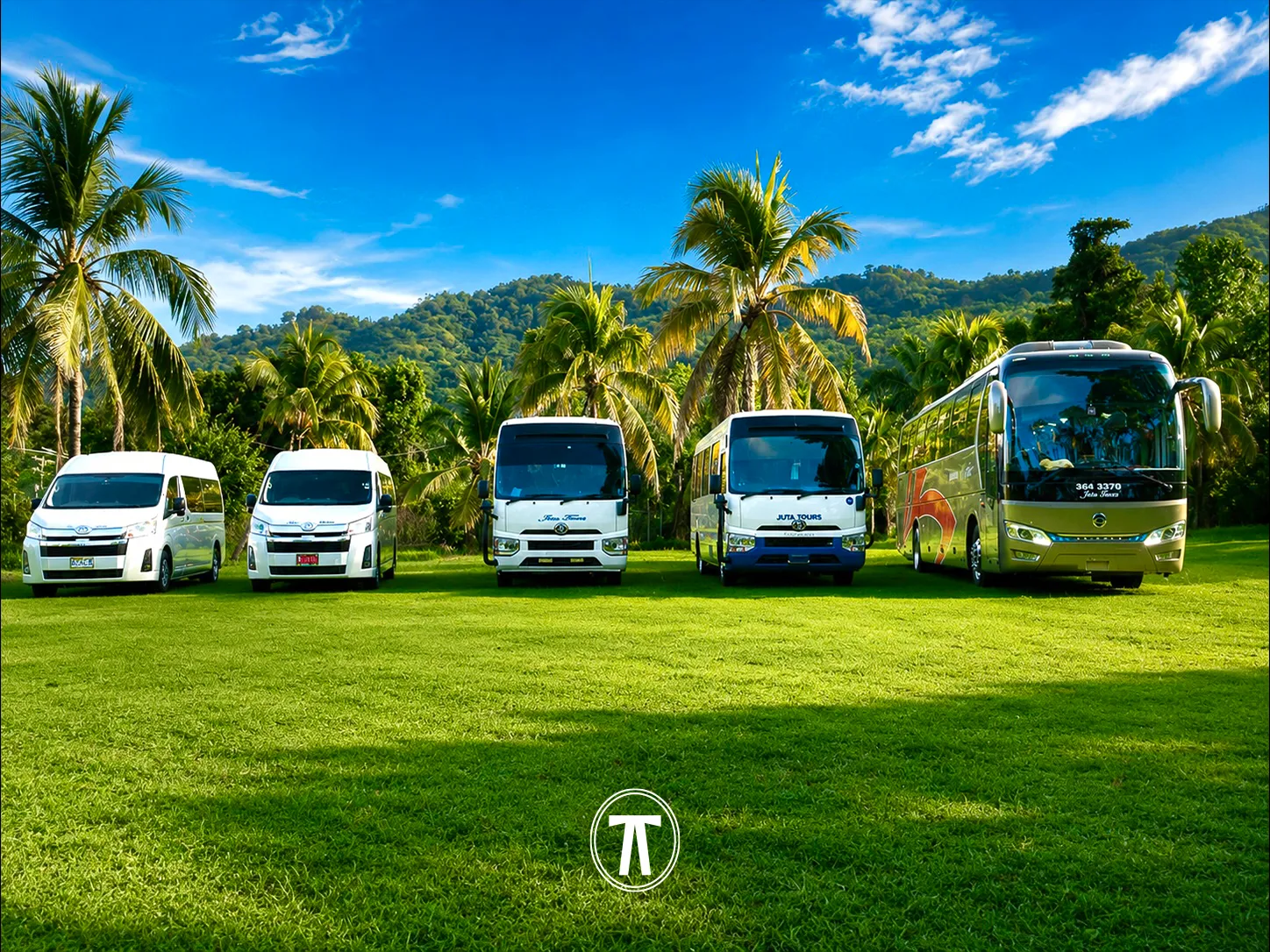 Line-up of vans, a mini coach, and a full-size coach parked together in a grassy field in Jamaica