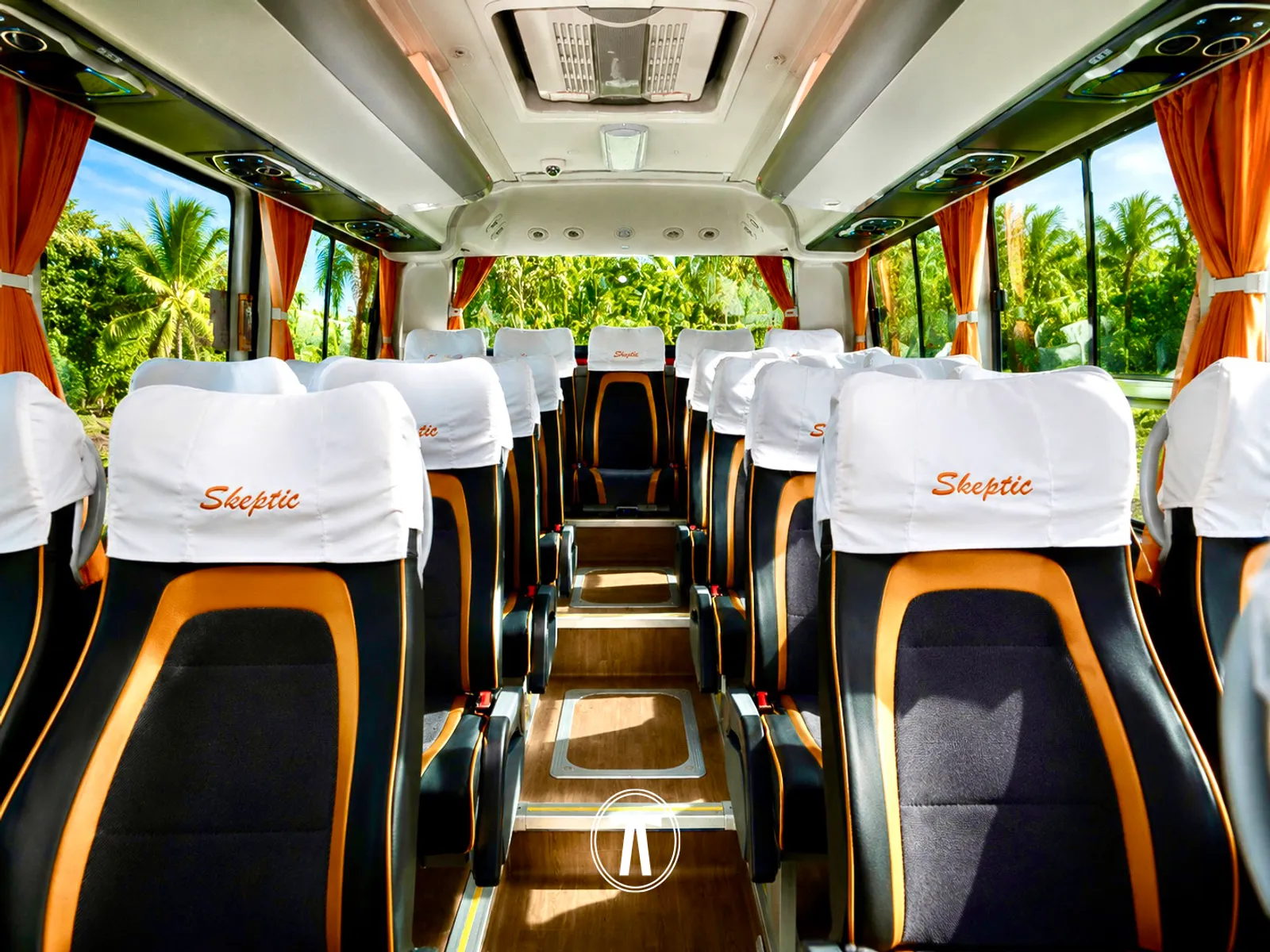 Coach interior with rows of seats, tropical greenery visible through the windows